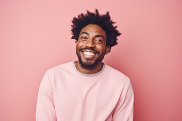 Obraz premium Portrait of a happy afro-american man in his 20s smiling at the camera isolated on solid pastel color wall