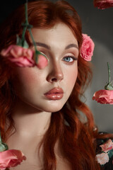 Red-haired woman with striking blue eyes looks away, surrounded by delicate pink roses
