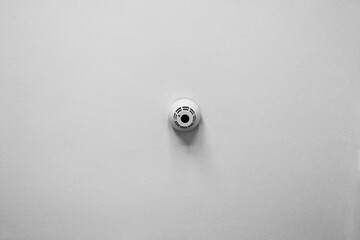 Minimalist Smoke Detector on White Wall for Home Safety and Security Design