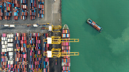 top down view from drone, crane lift container into the transport ship in commercial port, shipping...