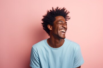 Obraz premium Portrait of a joyful afro-american man in his 20s laughing on solid pastel color wall