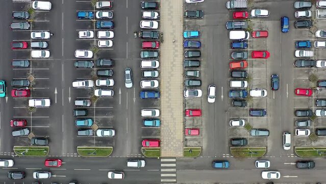 Aerial footage of a busy car park in the town of Seacroft in Leeds West Yorkshire in the UK, showing cars parking and looking for parking spaces in the Tesco supermarket carpark