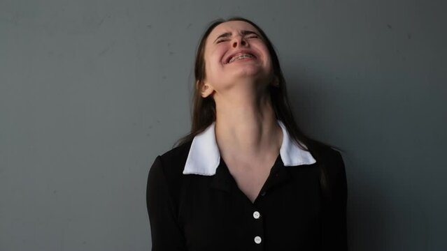 portrait of a young brunette woman in panic screaming in pain