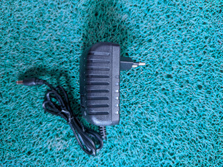 A sleek black adapter stands out against a green background