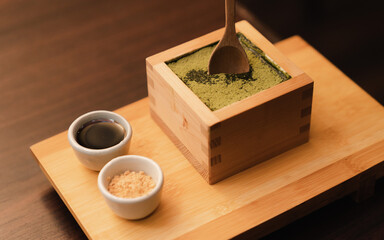 Japanese dessert topping with matcha green tea powder in wooden box.