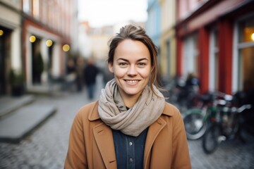 Fototapeta premium Portrait of a content woman in her 30s smiling at the camera isolated in scandinavian-style interior background