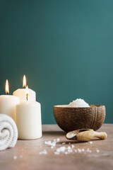 Drei brennende Kerzen ein Handtuch und Badesalz in einer Schüssel. Stillleben, Wellness, Spa.