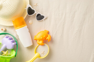 Child-friendly sun care setup at the shore. Top view of SPF lotion, play tools, hat, shades on...