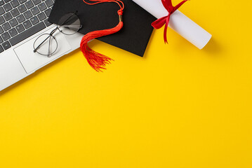 Online learning success theme. Top view of laptop, graduation cap, diploma, glasses on vibrant yellow backdrop. Perfect for educational promotions