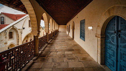 a narrow walkway with arches, windows and a gate that leads to an ancient building