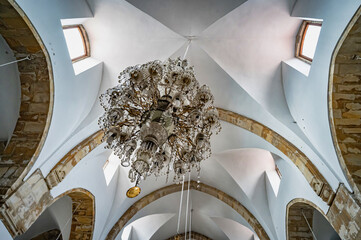 a chandelier is above a stone and brick room
