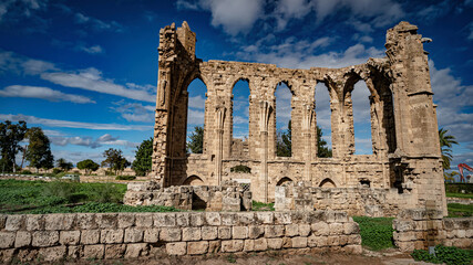 a stone structure that looks like an ancient roman aqueduct with ruins in front