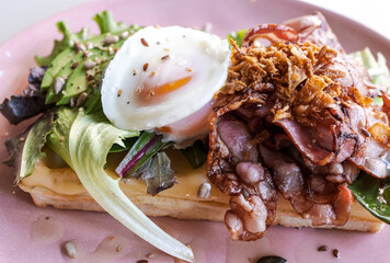 Delicious sandwich with bacon, avocado and eggs .