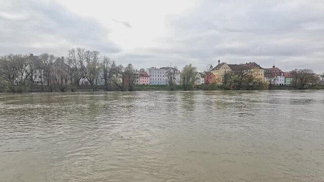 Flood of river regnitz in Bamberg with buildings in the background and leafless trees