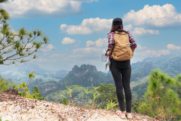 Naklejka premium Hikers backpacks standing on top of a mountain and enjoying nature view