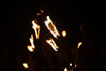 A beautiful close-up of a burning torch with fire flames during the summer festival. Bright fire in...
