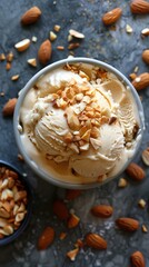 Overhead shot of light beige ice cream in a grey pot with almonds on background 