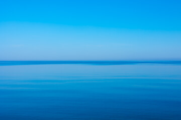 A very calm Baltic sea water surface with reflections of the sun. Beautiful summer scenery of Northern Europe.