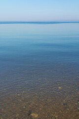 Obraz premium A very calm Baltic sea water surface with reflections of the sun. Beautiful summer scenery of Northern Europe.