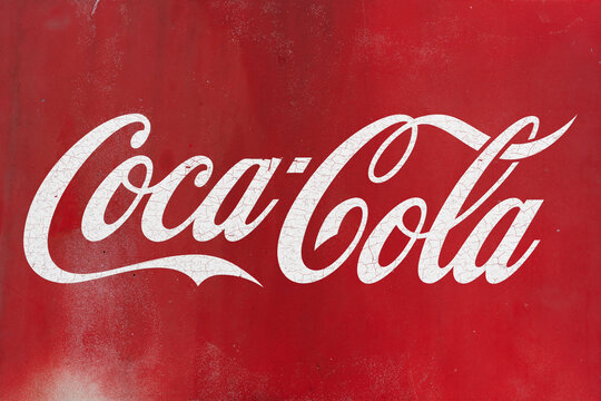 Distressed coca-cola logo on the red shabby metal backdrop. - Belgrade, Serbia, 21 may 2024
