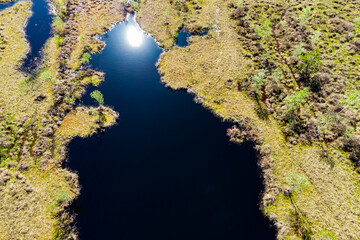 Aerial view of a picturesque peat bog with dark blue water