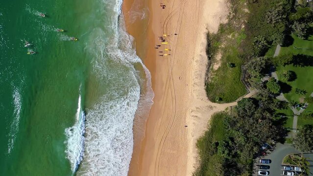 Bird's eye drone footage of the Coral Sea waves on Kawana Beach in Buddina in Queensland, Australia