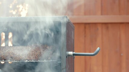 Closeup shot of cooking a meatloaf in a smoker box out door in the backyard garden on a sunny day