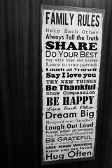 Creating a Warm Home. Family Rules and Positive Quotes on a Wooden Door. Black and white,...