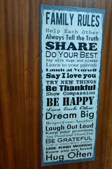 Creating a Warm Home. Family Rules and Positive Quotes on a Wooden brown Door.