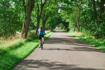 Woman riding bike in countryside sunny day