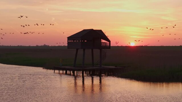 Aerial view of serene birdwatcher's hut at sunrise over Wadden Sea, Kiekkaaste, Netherlands.