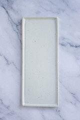 rectangle white handmade ceramic plate on marble table background.