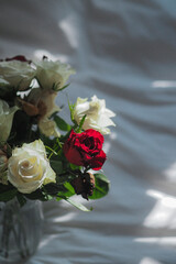 Flower-filled vase on bed with pillow