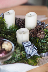 Illuminated candles amidst greenery on a tabletop