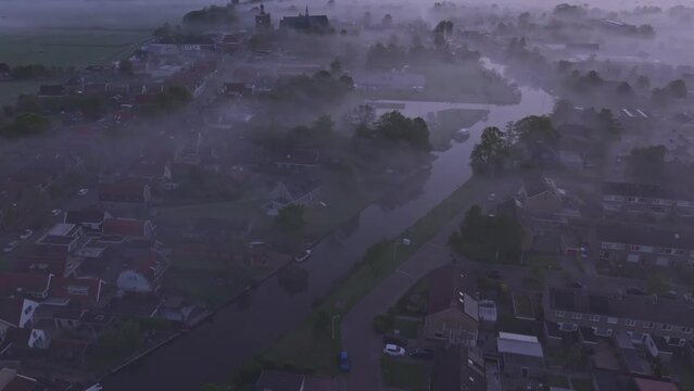 Aerial view of foggy city with river and church at sunrise, Workum, Friesland, Netherlands.