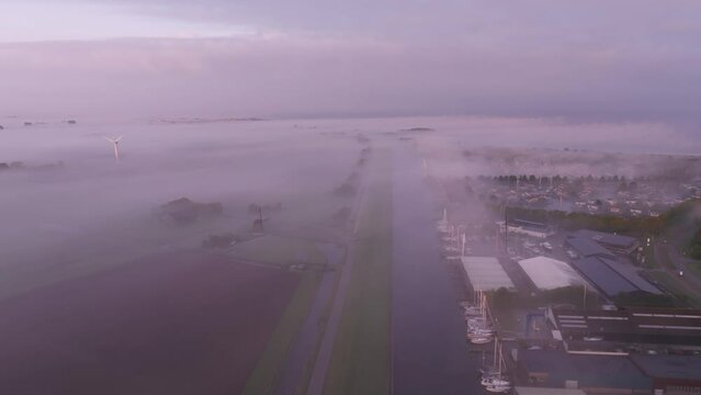 Aerial view of foggy marina and windmill at sunrise, Workum, Friesland, Netherlands.