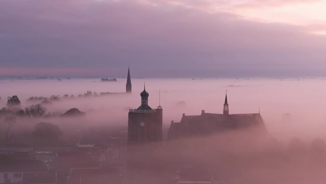 Aerial view of foggy city with church tower during sunrise, Workum, Friesland, Netherlands.