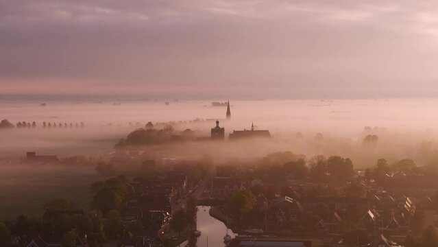 Aerial view of foggy sunrise over cityscape with church, Workum, Netherlands.