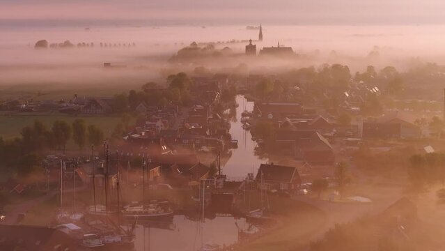 Aerial view of foggy sunrise over serene city with church, Workum, Friesland, Netherlands.