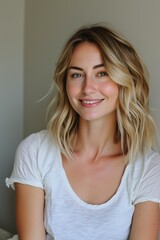 Fototapeta premium professional photo of beautiful blonde woman, shoulder length hair with soft waves, wearing white t-shirt, smiling at camera