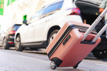 Obraz premium Tourist taking suitcase from car trunk. Travel and vacations concept.