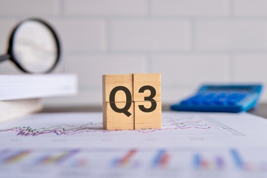 Close up image of wooden cubes with alphabet Q3 on office desk. Third quarter concept.