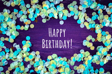 Happy birthday greeting card with confetti and golden stars, with typography, on a purple background