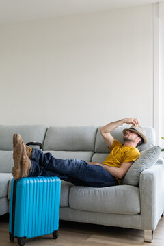 Woman resting in the living room of her house until it's time to go to the airport. Woman resting on the sofa waiting for her flight time. Woman on vacation has just arrived at the hotel.