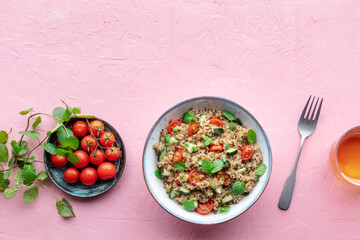Quinoa tabbouleh salad in a bowl, a healthy dinner with tomatoes and mint, shot from the top with a place for text