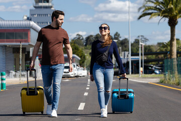 Couple leaving the airport with their suitcases. Couple on honeymoon in their favorite city. Couple...