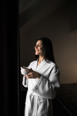 Young woman enjoying aromatic espresso coffee in the morning in a hotel room.Coffee concept