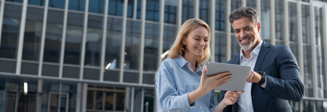 Banner with successful business people discussing business project as team. Mature 40s years old man businessman ceo, young adult woman businesswoman employee work together on pc tablet. Copy space