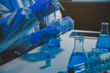 chemist,scientist hand dropping chemical liquid into test tube, science research and development concept