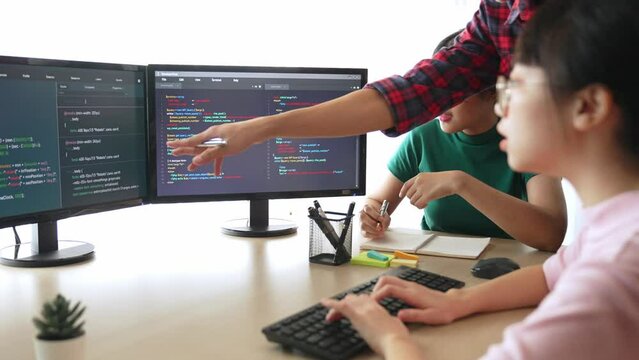 Slow motion back end software developer engineer for computer programming working together on debugging writing computing code, solving complex algorithms display on monitor in office. Burgeoning